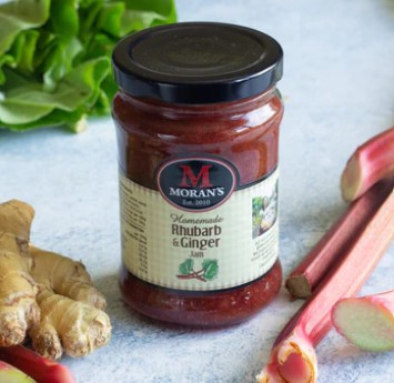 Moran's Mega Jam Rhubarb and Ginger jam pictured on a counter with ingredients displayed around it.