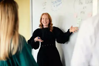 Woman presenting in front of a white board