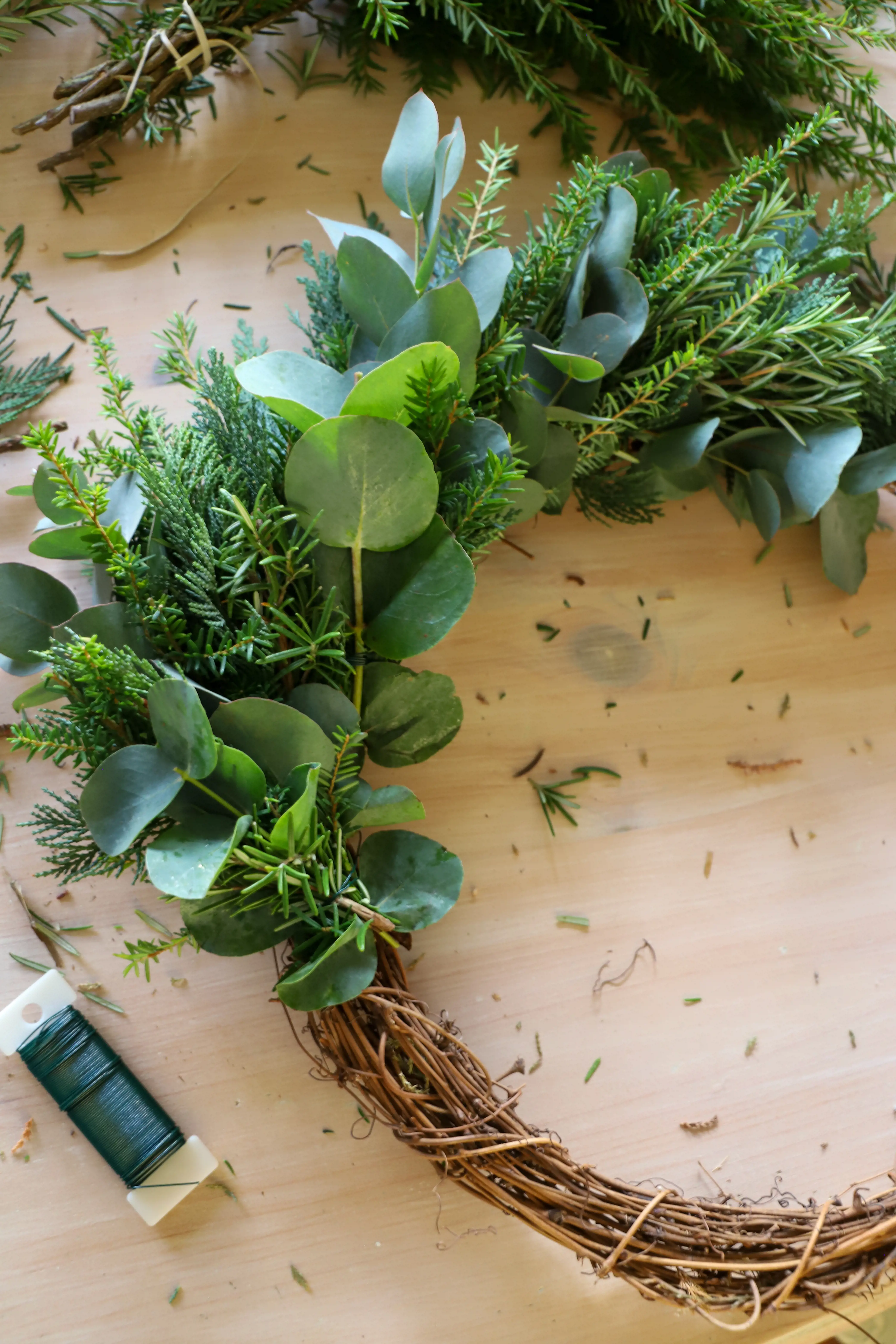 green foliage twisted halfway around wreath base