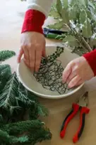 hands in bowl holding chicken wire